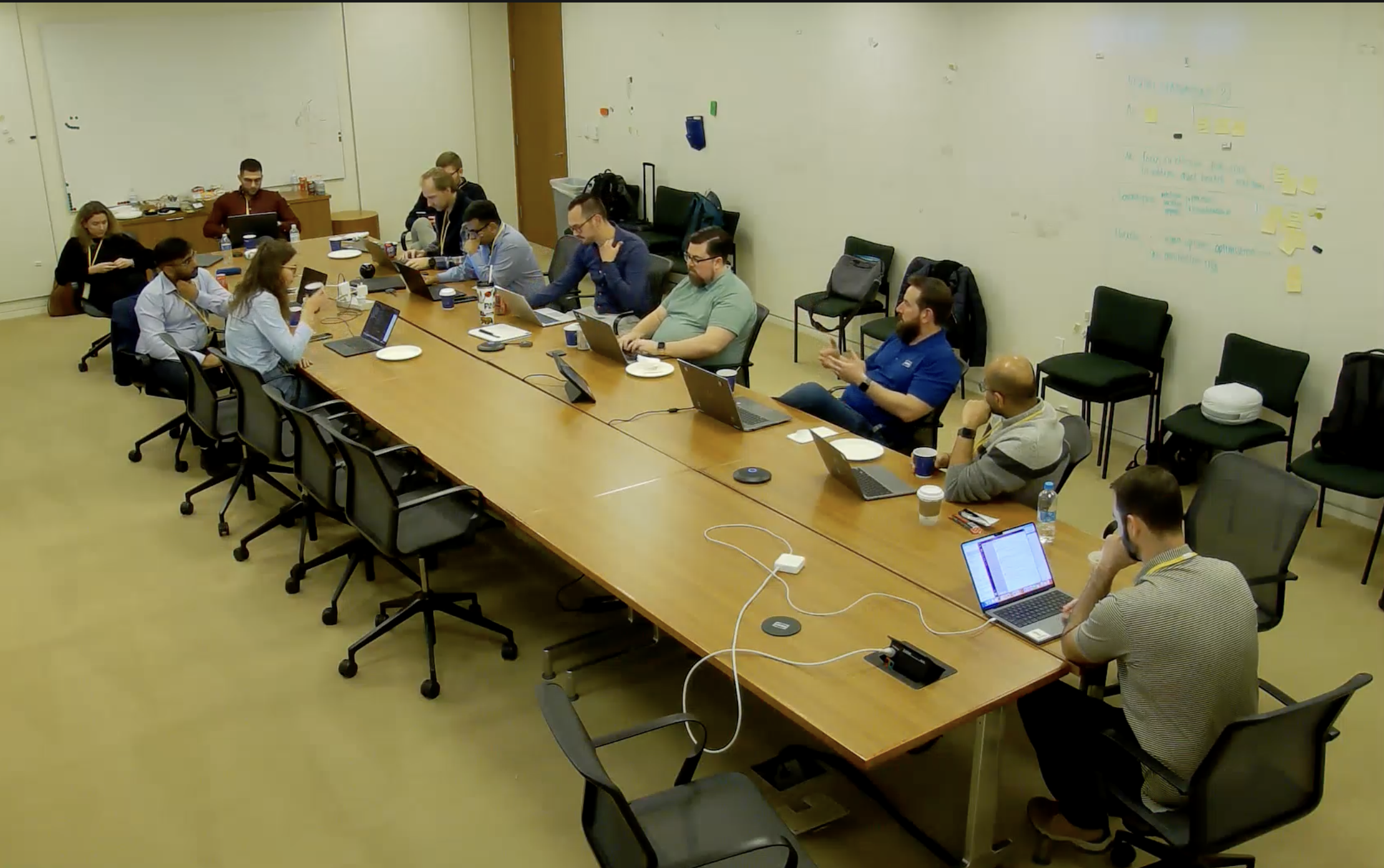 Working session around a long table with laptops